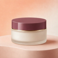 Trinidy MK Velvet Bloom Whipped Body Butter jar with a plum lid on a peach studio pedestal