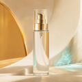 Trinidy MK Sunlit Shimmer Dry Body Oil pump bottle glowing in golden light beside aqua reflections